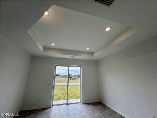 empty room featuring a raised ceiling