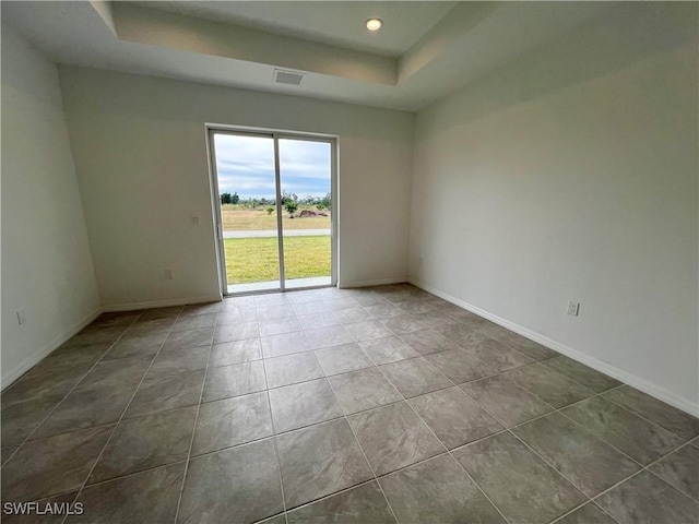 unfurnished room featuring a raised ceiling