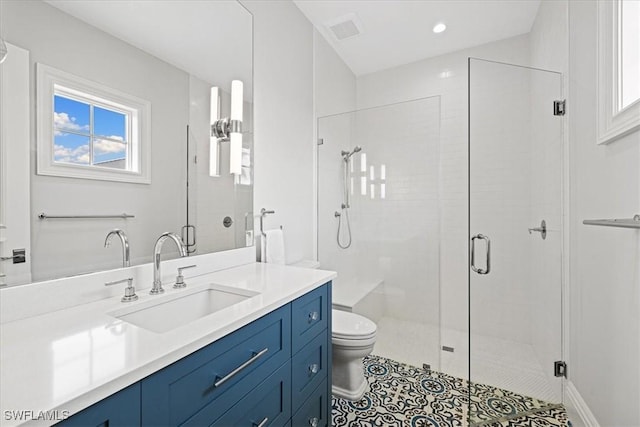 bathroom with tile patterned floors, vanity, toilet, and a shower with door