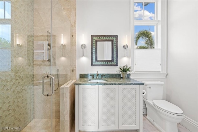 bathroom featuring vanity, toilet, and a shower with shower door