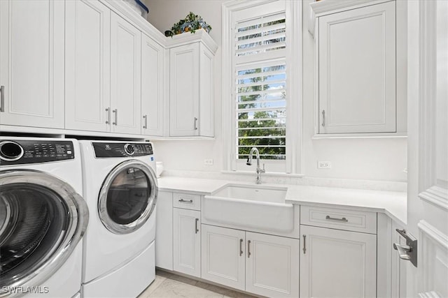 laundry area featuring cabinets, washer and dryer, and sink