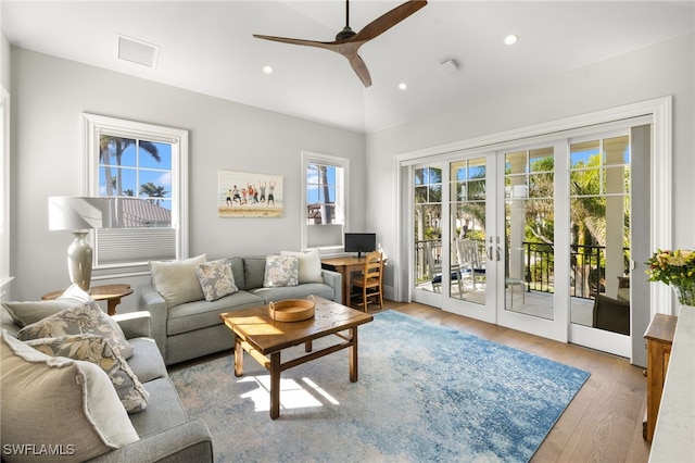 living room with ceiling fan, french doors, hardwood / wood-style floors, and lofted ceiling