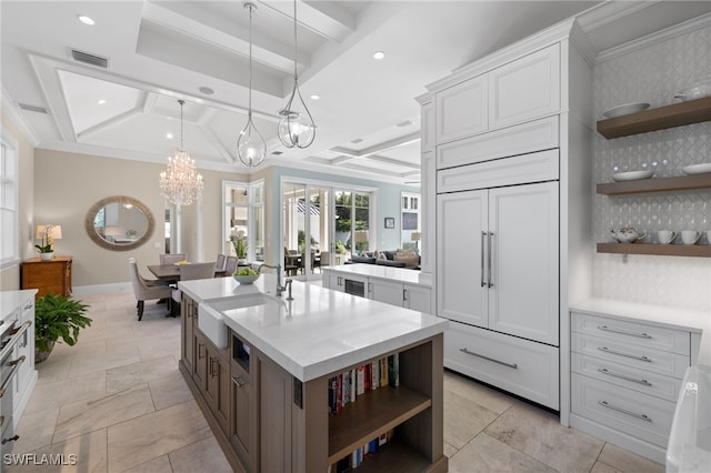 kitchen with white cabinetry, sink, coffered ceiling, beamed ceiling, and ornamental molding