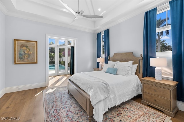 bedroom featuring access to outside, multiple windows, ceiling fan, and light hardwood / wood-style flooring