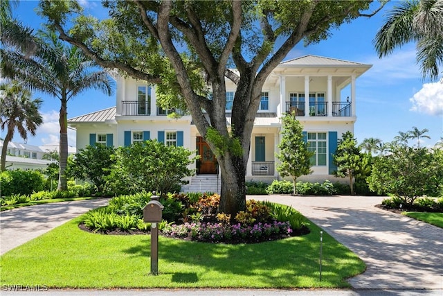 view of front of home featuring a balcony and a front lawn