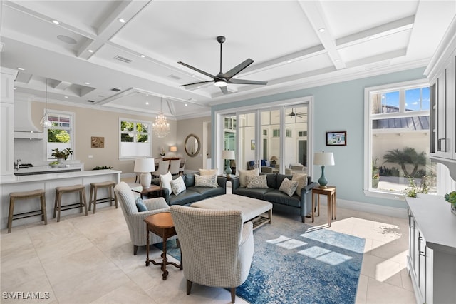 tiled living room with ceiling fan with notable chandelier, beam ceiling, and coffered ceiling