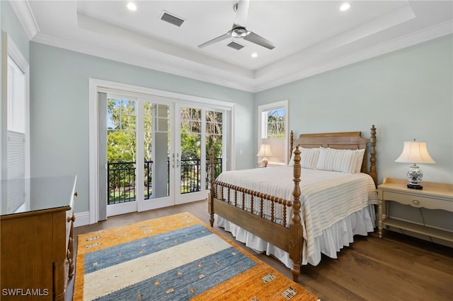 bedroom with ceiling fan, a raised ceiling, dark hardwood / wood-style floors, crown molding, and access to outside