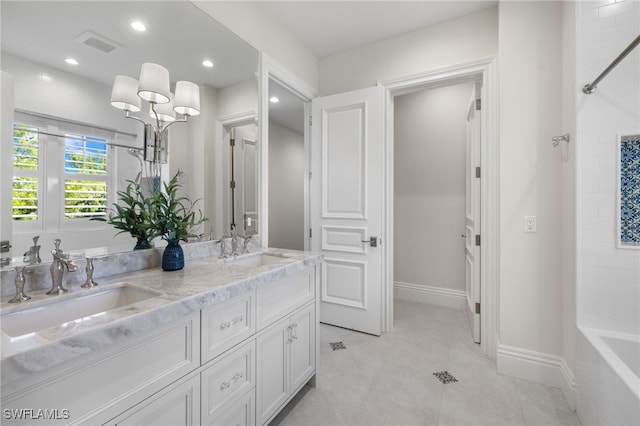 bathroom featuring tile patterned flooring, vanity, and tiled shower / bath