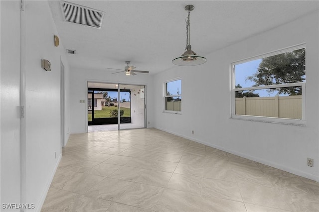 tiled spare room with ceiling fan