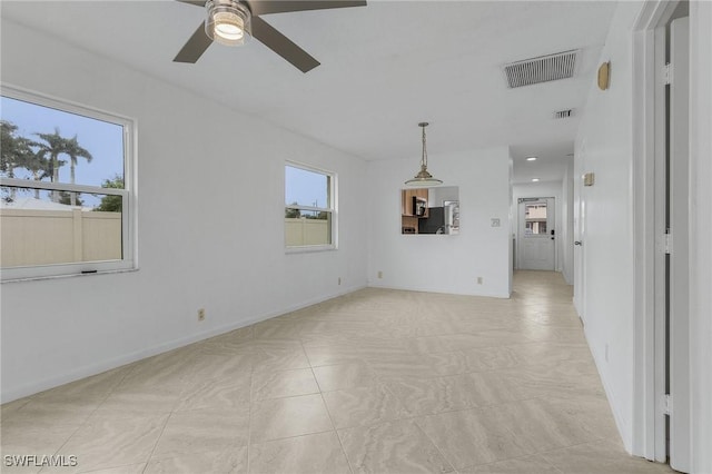 unfurnished living room featuring ceiling fan and a healthy amount of sunlight