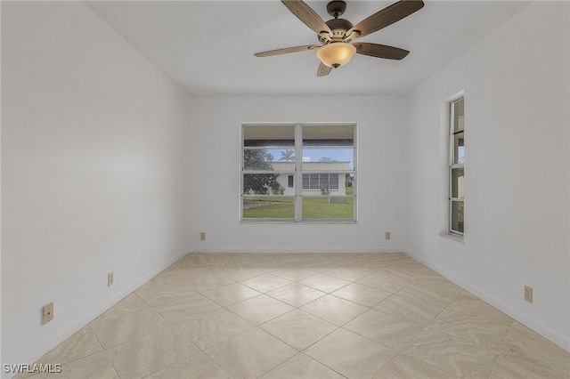 unfurnished room with ceiling fan and light tile patterned flooring