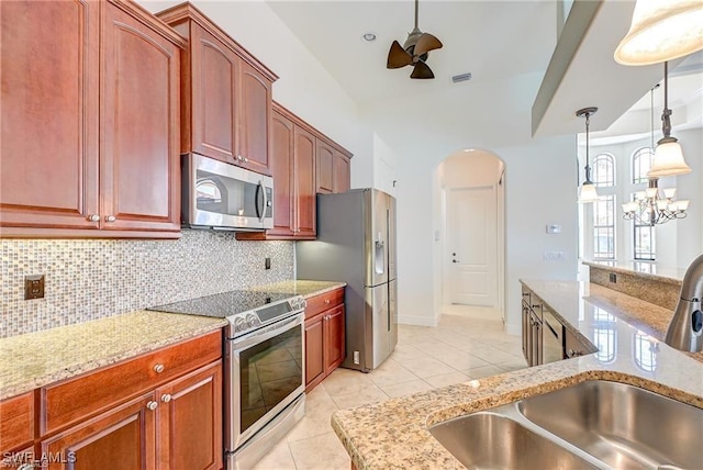 kitchen with stainless steel appliances, light tile patterned floors, decorative backsplash, an inviting chandelier, and sink