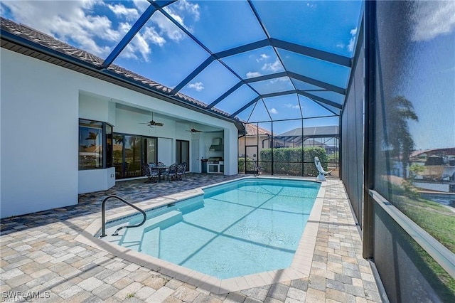 view of pool featuring a patio area, ceiling fan, and glass enclosure