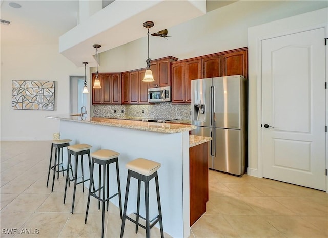 kitchen with stainless steel appliances, light tile patterned flooring, decorative light fixtures, and backsplash