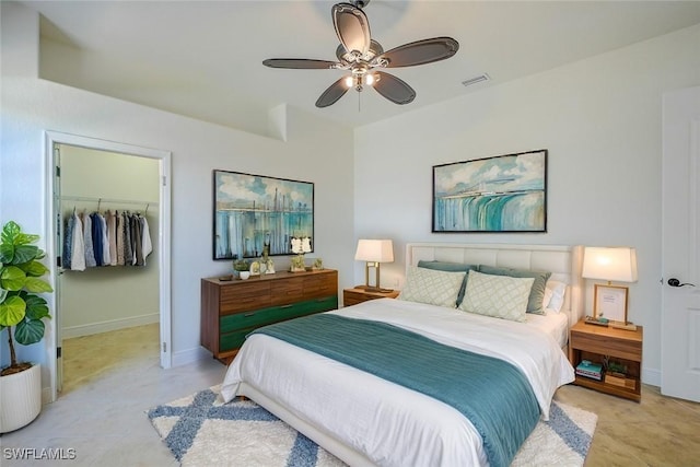 bedroom featuring ceiling fan, a walk in closet, and a closet