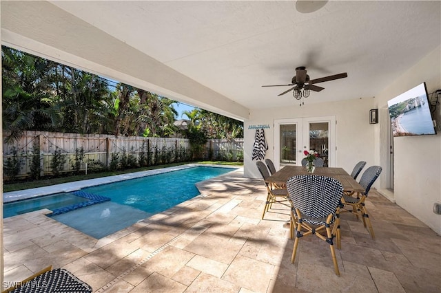 view of swimming pool with ceiling fan, a patio area, and french doors