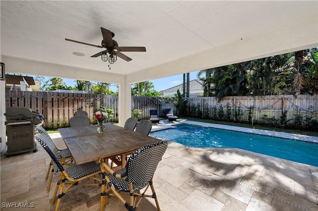 view of swimming pool with grilling area, ceiling fan, and a patio