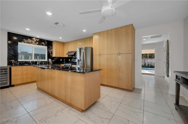 kitchen featuring dark stone counters, wine cooler, tasteful backsplash, a kitchen island, and stainless steel appliances