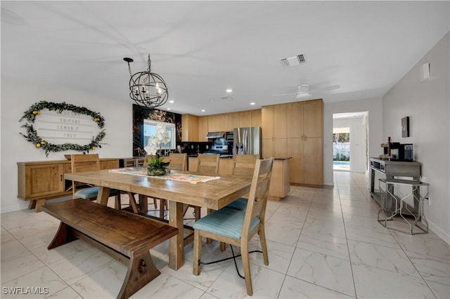 dining area featuring ceiling fan with notable chandelier