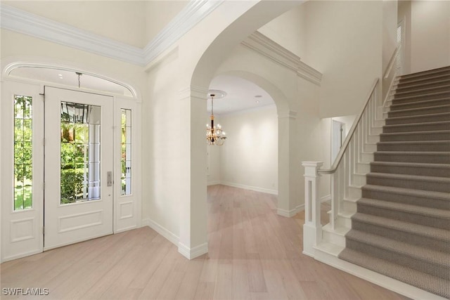 8723 La Palma Ln, Naples, FL 34108 - entrance foyer featuring wood finished floors, stairs, a chandelier, and arched walkways