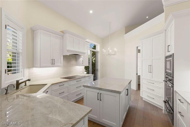 8723 La Palma Ln, Naples, FL 34108 - kitchen with a warming drawer, a chandelier, tasteful backsplash, appliances with stainless steel finishes, and a center island