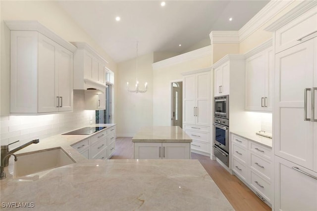 8723 La Palma Ln, Naples, FL 34108 - kitchen with a chandelier, appliances with stainless steel finishes, tasteful backsplash, white cabinetry, and lofted ceiling