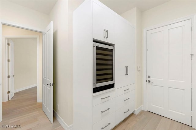 8723 La Palma Ln, Naples, FL 34108 - interior space featuring wine cooler, light wood-style flooring, and white cabinetry
