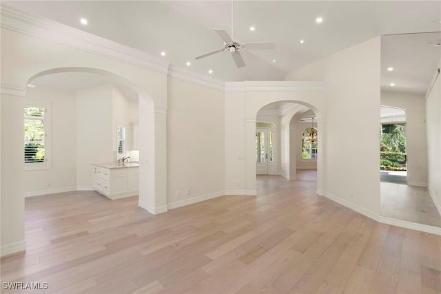 8723 La Palma Ln, Naples, FL 34108 - unfurnished living room featuring a ceiling fan, light wood-style floors, arched walkways, recessed lighting, and a high ceiling