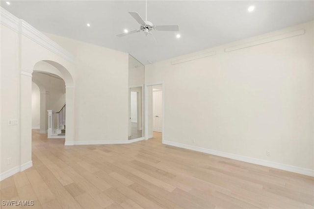 8723 La Palma Ln, Naples, FL 34108 - unfurnished room with arched walkways, ceiling fan, high vaulted ceiling, light wood-style flooring, and stairway