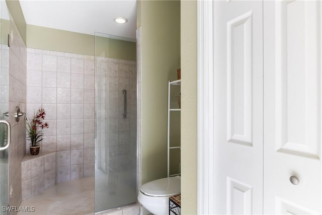 bathroom featuring an enclosed shower, toilet, and tile patterned floors