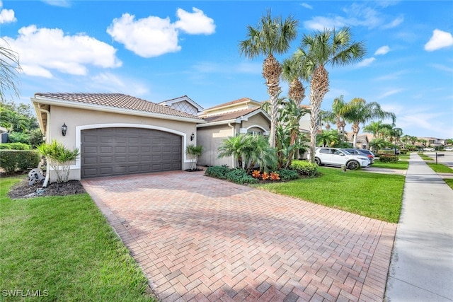 mediterranean / spanish-style home featuring a front yard and a garage