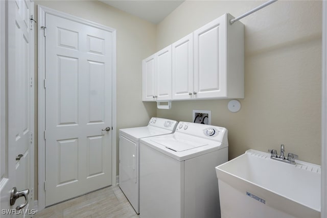 washroom with washing machine and dryer, sink, and cabinets