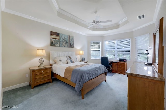 carpeted bedroom with a tray ceiling, ceiling fan, and crown molding