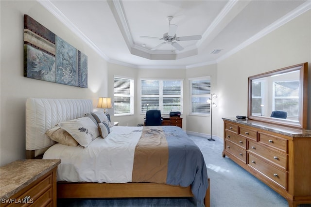 carpeted bedroom with ceiling fan, ornamental molding, and a tray ceiling