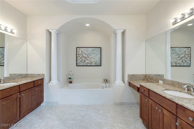 bathroom featuring tile patterned flooring, vanity, and a bath