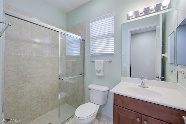 bathroom featuring vanity, a shower with shower door, and toilet