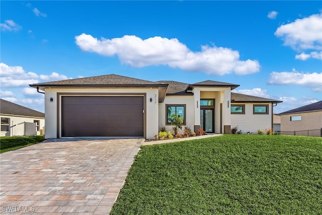 prairie-style home with a front yard and a garage