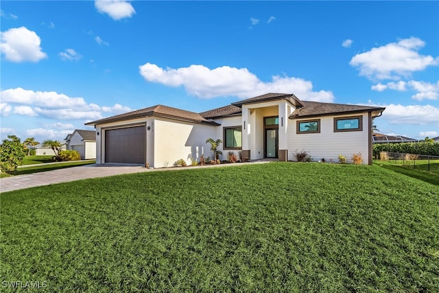 prairie-style home featuring a front lawn and a garage