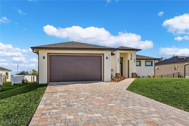 prairie-style home featuring a garage and a front lawn