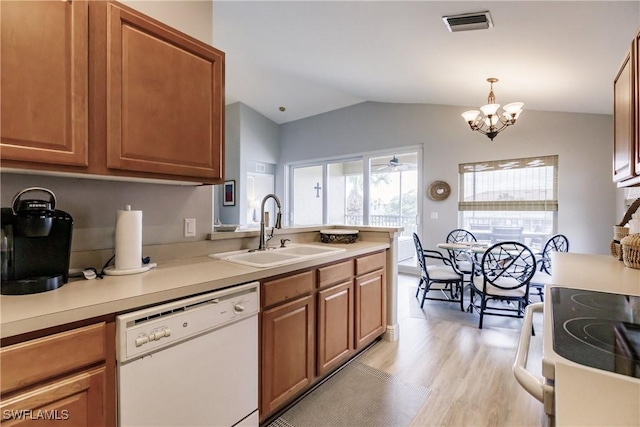 kitchen featuring pendant lighting, dishwasher, lofted ceiling, an inviting chandelier, and sink