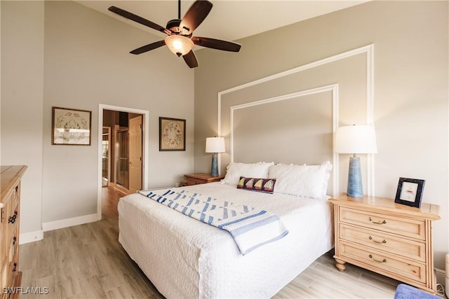 bedroom with ceiling fan, light hardwood / wood-style floors, and connected bathroom