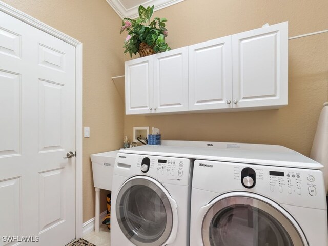 laundry room featuring ornamental molding, cabinets, and independent washer and dryer