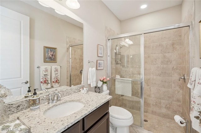 bathroom featuring toilet, an enclosed shower, and vanity