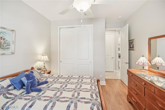 bedroom featuring light wood-type flooring, ceiling fan, and a closet