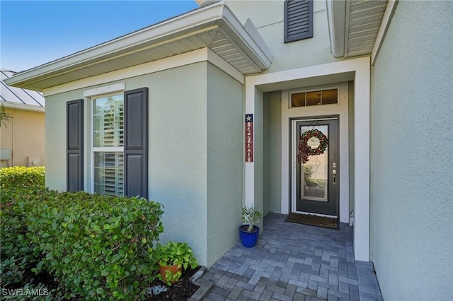 property entrance with stucco siding