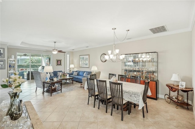 tiled dining room with ceiling fan with notable chandelier, ornamental molding, and a tray ceiling