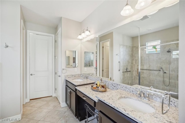 bathroom featuring a tile shower, tile patterned floors, and vanity