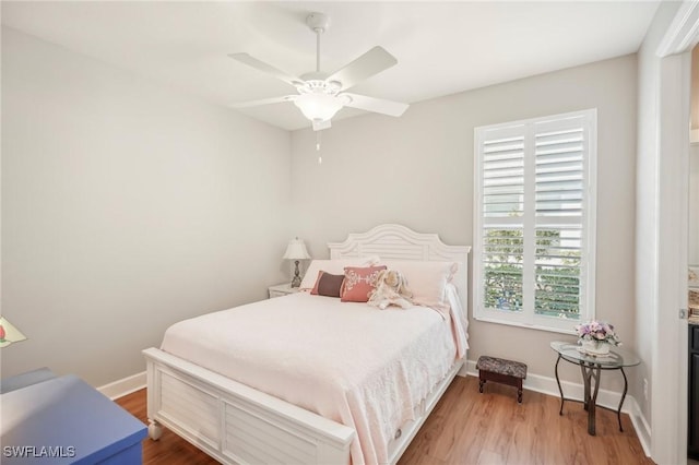 bedroom featuring multiple windows, ceiling fan, and light hardwood / wood-style flooring