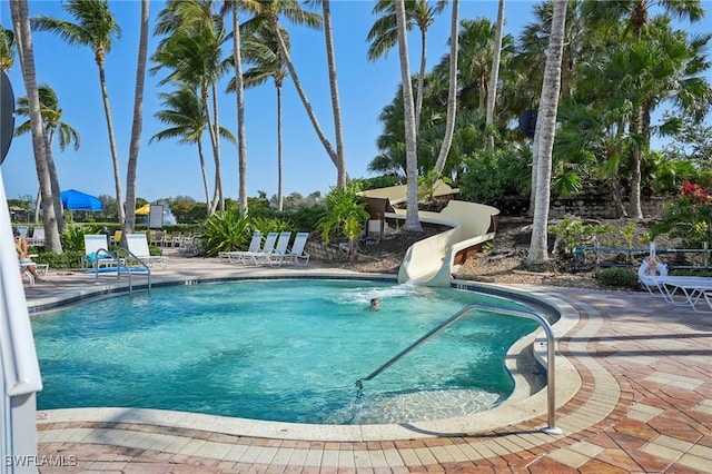 view of swimming pool with a patio and a water slide