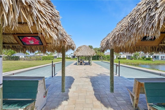 view of property's community with a water view, a lawn, and a gazebo